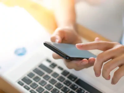 business-woman-hand-with-financial-charts-mobile-phone-laptop-table-768x576.jpg