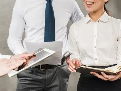 close-up-businesspeople-working-together-against-grey-wall.jpg